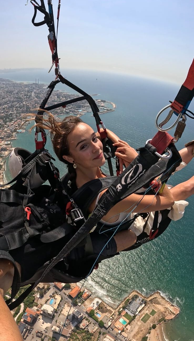 Passenger enjoying the coastal view during a tandem paragliding flight in Lebanon