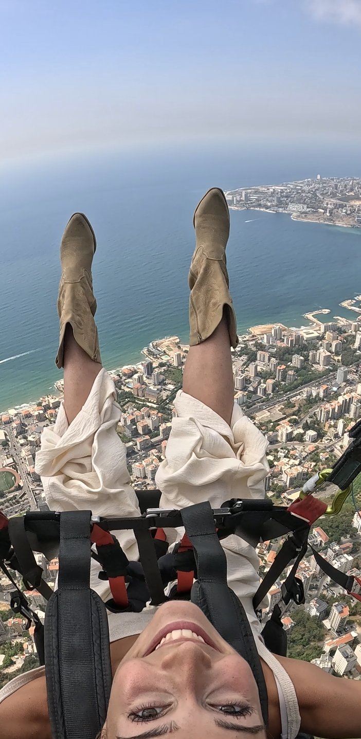 Laughing passenger flying high above Jounieh city and the coast