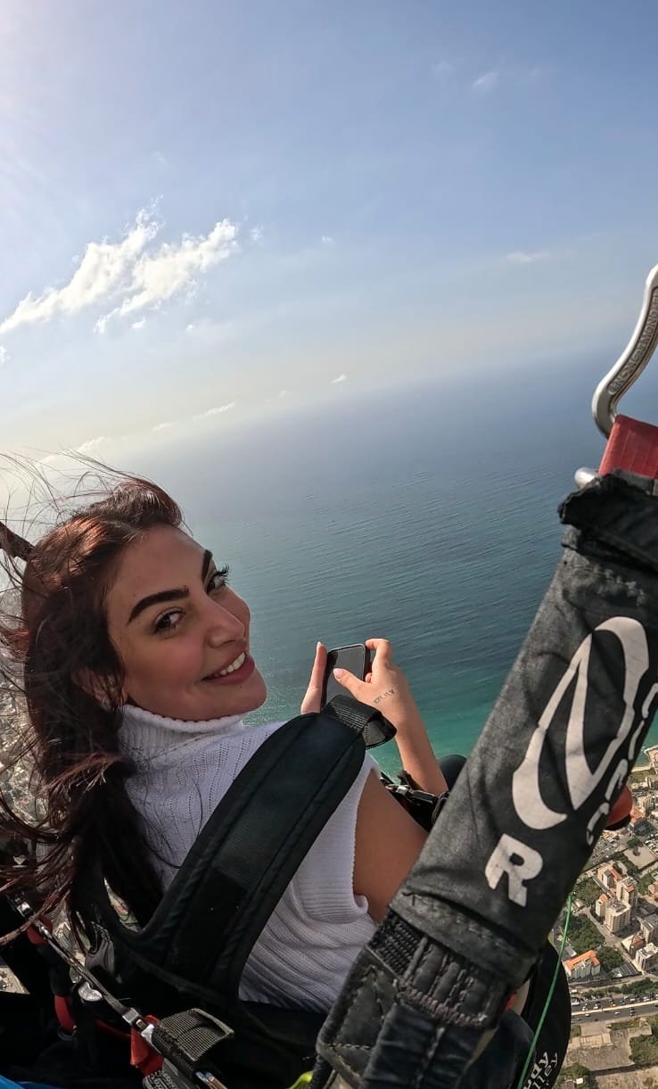 Passenger filming the Mediterranean coast during a tandem flight
